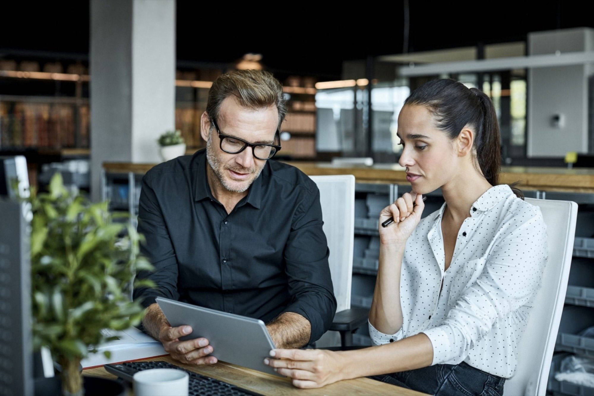 Man and women discussing on tablet